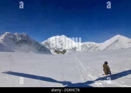 Ein CH-47F Chinook-Hubschrauber von B Company, 1. Bataillon, 52. Luftfahrtregiment wirft eine Schneewolke auf, als er auf dem Kahiltna-Gletscher landet, 22. April 2021. Flieger der Einheit, auch bekannt als die Zuckerbären, reisten von Fort Wainwright an, um dem National Park Service zu helfen, die notwendige Ausrüstung und Ausrüstung für das Basislager auf der 7,200-Fuß-Ebene des Kahiltna-Gletschers für die Klettersaison 2021 auf Denali zu besorgen, Der höchste Berg in Nordamerika. Der Berg hinter der Landung Chinook ist 17,400-Fuß-Mount Foraker. (Foto der Armee/John Pennell) Stockfoto