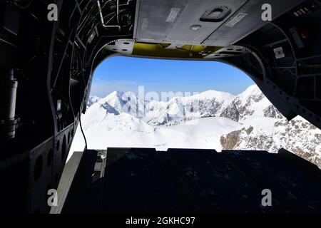 Die Berge der Alaska Range wurden von der Rückseite eines CH-47F Chinook Hubschraubers von B Company, 1. Bataillon, 52. Luftfahrtregiment, 22. April 2021 gesehen. Flieger der Einheit, auch bekannt als die Zuckerbären, reisten von Fort Wainwright an, um dem National Park Service zu helfen, die notwendige Ausrüstung und Ausrüstung für das Basislager auf der 7,200-Fuß-Ebene des Kahiltna-Gletschers für die Klettersaison 2021 auf Denali zu besorgen, Der höchste Berg in Nordamerika. (Foto der Armee/John Pennell) Stockfoto