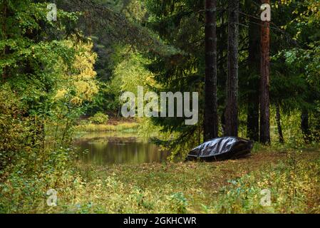 Ein altes Metallboot wird in der Herbstsaison mit eigenen Händen am Ufer des Sees gebaut. Stockfoto