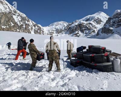 Soldaten der Bravo Company, 1. Bataillon, 52. Luftfahrtregiment, aus Fort Wainwright, entladen Ausrüstung und Lieferungen für den National Park Service auf dem Kahiltna Gletscher im Denali Nationalpark. Die Einheit leistet jährlich Hilfe bei der Versorgung des Basislagers, das sich in einer Höhe von 7,200 Fuß befindet. Stockfoto
