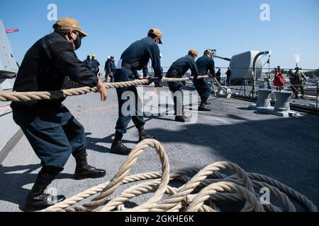 210422-N-HG846-0013 YOKOSUKA, Japan (23. April 2021) – Seeleute nehmen am 23. April an Bord des Lenkflugkörper-Zerstörers USS Rafael Peralta der Arleigh Burke-Klasse (DDG 115) eine Anlegestelle ein. Rafael Peralta ist der Task Force 71/Destroyer Squadron (DESRON) 15 zugeordnet, der größten vorwärtseingesetzten DESRON der Marine und der wichtigsten Surface Force der 7. US-Flotte. Stockfoto