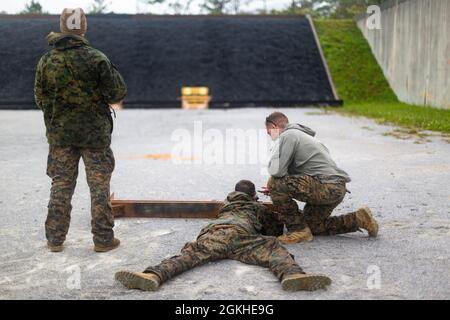 US-Marineinfanteristen mit amphibischem Aufklärungszug (ARP), 31. Marine Expeditionary Unit (MEU), erhalten während des Schießens von Zielen in Camp Hansen, Okinawa, Japan, 22. April 2021 Coaching. ARP führt regelmäßig Live-Feuerübungen durch, um die Kenntnisse über mehrere Waffensysteme zu erhalten. Die 31. MEU, die einzige kontinuierlich im Vorlauf eingesetzte MEU des Marine Corps, stellt eine flexible und tödliche Truppe bereit, die als führende Krisenreaktionstruppe in der Indo-Pazifik-Region eine breite Palette von Militäroperationen durchführen kann. Stockfoto