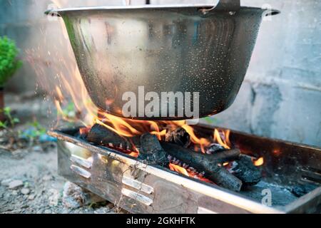 Topf Kessel über offenem Feuer, Vorbereitung Eintopf Suppe auf Holzgrill, Kochen im Freien Stockfoto