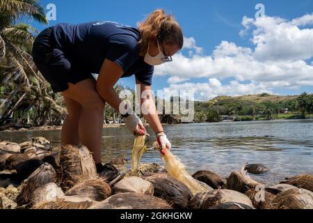 INALÅHAN, Guam (23. April 2021) LT. Meagan Morrison, Public Affairs Officer bei Commander, Submarine Squadron 15, aus Gravette, Arkansas, sammelt Müll aus den Felsen. CSS-15 und Naval Submarine Training Center Pacific, Detachment Guam, haben sich mit ihrem Schwesterdorf Inalåhan während einer Freiwilligenveranstaltung zum Thema Umweltfreundlichkeit zusammengeschlossen, um den Earth Day zu würdigen. Stockfoto