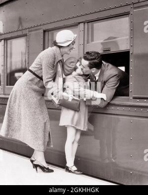 1930ER-JAHRE-FRAU MUTTER AUF DEM PASSAGIERZUGBAHNHOF MIT MÄDCHEN TOCHTER KÜSSEN MANN VERLASSEN VATER DURCH OFFENES FENSTER - R6054 HAR001 HARS REISE KISS MAMA KÜSSEN STRESS NOSTALGISCHE EISENBAHN-PAAR GESCHÄFTSLEUTE VORORT STÄDTISCHEN MÜTTER ALTEN ZEIT BESCHÄFTIGT NOSTALGIE UMARMT ZÜGE ALTE MODE 1 DURCH JUVENILE ANGST HALS STARKE EISENBAHN FAMILIEN FREUDE LIFESTYLE FRAUEN VERHEIRATET EHEGATTEN EHEMÄNNER PASSAGIER KOPIEREN RAUM IN VOLLER LÄNGE DAMEN TÖCHTER PERSONEN VERMISSEN FÜRSORGLICHE MÄNNER TRANSPORT VÄTER B&W PARTNER TRAURIGKEIT BAHNPLATTFORM VERKAUFT GLÜCK KOPF UND SCHULTERN SEINE VÄTER DIE SPANNUNG BEGINNT Stockfoto