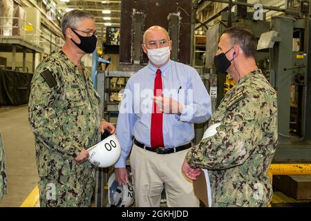 SILVERDALE, Washington (23. April 2021) – Vice ADM. William Galinis (rechts), Kommandant, Naval Sea Systems Command, spricht mit Kapitän Robert Figgs (links), Kommandooffizier, Trident Refit Facility Bangor (TRFB), und Edward Ingles (Mitte), Executive Director, TRFB, während einer Tour bei TRFB am 23. April. Galinis besuchte TRFB und andere Kommandos in der Nordwestregion, um sich über den Status verschiedener Wartungsmöglichkeiten zu informieren und die Prozessverbesserungen und Transformationsbemühungen zu besprechen. Stockfoto