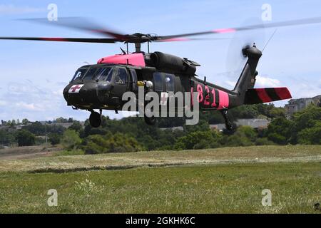 Ein CAL-FEUERWEHRMANN sieht zu, wie eine Nationalgarde der California Army UH-60 Black Hawk nach einem Helikopter-Eimer-Training am 24. April 2021 auf der Allen Helibase in der Nähe von Sutter Creek, Kalifornien, landet. CAL Guard und CAL FIRE führen diese gemeinsame Schulung jährlich durch, um beiden Behörden Erfahrungen in der Zusammenarbeit während der Wasserfalleinsätze zu vermitteln, um sich auf die Notwendigkeit vorzubereiten, während der kalifornischen Feuersaison Militärflugzeuge und -Crews zur Bekämpfung von Waldbränden einzusetzen. Stockfoto