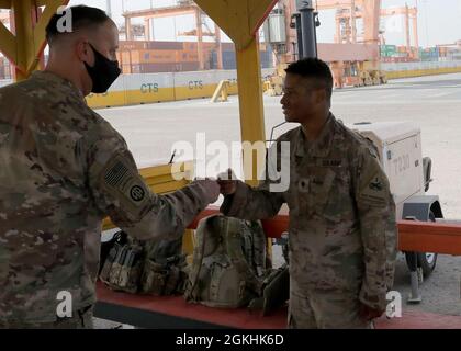 Armee Reserve Brig. General Justin M. Swanson, der stellvertretende Kommandeur des 1. Theatre Sustainment Command, pumpt SPC mit der Faust. Demarcus Russ nach der General-Tour am 24. April 2021 durch den Hafenbetrieb im Kuwait-Hafen Shuaiba. Der General dankte den Soldaten für die Bereitstellung von Sicherheit während der Auslastungs- und Einladeoperationen, als der gebürtige New Orleans erfuhr, dass der Spezialist mit dem Soldaten der 1. Panzerdivision in Jonesville, Louisiana, aufgewachsen ist. Stockfoto