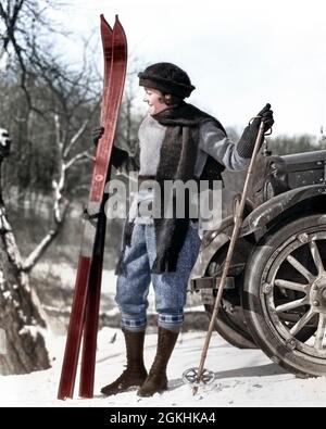 FRAU AUS DEN 1920ER JAHREN IM SCHAL HUT UND STIEFEL STEHEN VOR DEM AUTO MIT HOLZSKIERN UND BAMBUSSKISTÖCKEN - W82C HAR001 HARS JUNGE ERWACHSENE LIFESTYLE FRAUEN VERTIKAL LÄNDLICHEN ERWACHSENEN WOLLE VOLLE LÄNGE AUTOMOBILRÄDER VERTRAUEN BOOT WINTERZEIT VERÖFFENTLICHT WINTERSAISON AKTIVITÄT BAMBUS ABENTEUER HOBBY FREIZEIT AUTOS AUFREGUNG HOBBYS ERHOLUNG AUTOMOBIL AUTOFAHREN JAHRESZEITEN AUTOS STYLISH AUTOFAHRER ERHOLUNG WINTER ENTSPANNUNG SAISON WANDERN JUNGE ERWACHSENE FRAU KAUKASISCHE ETHNIE HAR001 ALTMODISCH Stockfoto