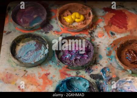 Annäherung an eine Palette mit Kreisen, auf Wasserfarbe in verschiedenen Farben, Objekt und Werkzeug für Malerei, Hobby und Tapete Details im Studio Stockfoto