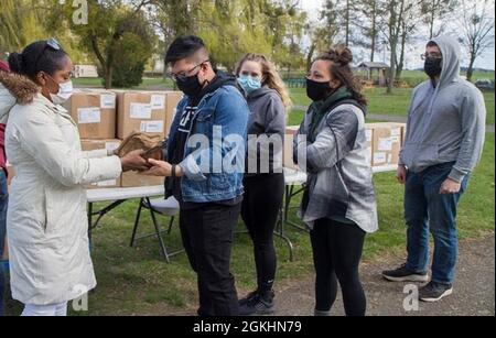 Spc. Rose Georges (links) übergibt am 25. April 2021 eine Gruppe von Soldaten, die am 108. Medical Company Area Support (MCAS) der Pennsylvania Guard am Standort Powidz, Polen, eingesetzt wurden, MIT USO-Care-Paketen, die Snacks und Hygieneartikel enthalten. Georges ist ein administrativer Spezialist, der der 50. Regionalen Unterstützung der Florida Guard aus Homestead, Florida, zugewiesen wurde. Stockfoto