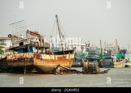 Fischerhafen mit festgeschütteten Booten und einige ruiniert an der Küste von Phuket Stadt in Thailand Stockfoto