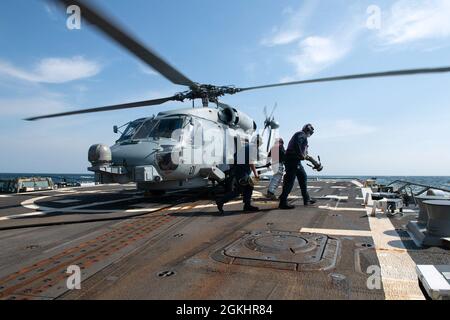 210426-N-HG846-0008 PAZIFISCHER OZEAN (27. April 2021) – Matrosen bereiten sich darauf vor, den MH-60R Seahawk, der dem Hubschrauber-Seeschlagerschwadron (HSM-51) an Bord des Lenkflugkörper-Zerstörers USS Rafael Peralta (DDG 115) der Arleigh Burke-Klasse zugewiesen wurde, am 27. April aufzutanken. Rafael Peralta ist der Task Force 71/Destroyer Squadron (DESRON) 15 zugeordnet, der größten vorwärtseingesetzten DESRON der Marine und der wichtigsten Surface Force der 7. US-Flotte. Stockfoto