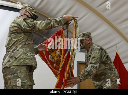 LT. Col. Phillip Hill, Commander, 1-181. Field Artillery Regiment, und Command Sgt. Maj. Carlos Quick, Kommandofeldwebel Major, 1-181 FAR, entfärbt die Farben des 1.-181. FAR während einer Zeremonie zur Übertragung der Autorität am 26. April 2021 im Camp Arifjan, Kuwait. LT. Oberst Andrew Hercik sagte zu Mitgliedern des 1.-181. FAR: „Ich bin zuversichtlich, dass Valor weiterhin wachsen und die Mission aufbauen wird und gleichzeitig demonstrieren wird, warum der König der Schlacht nicht nur relevant, sondern auch entscheidend für den Erfolg auf allen Kriegsebenen bleibt.“ Stockfoto