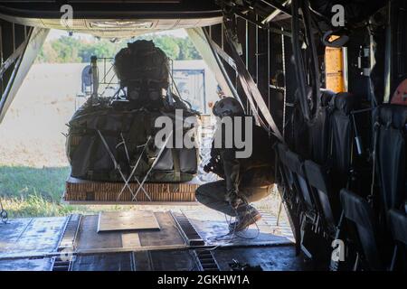 U.S. Marine Corps CPL. Isaiah Daniels führt ein Joint Precision AirDrop System (JPADS) auf einen CH-53E Superhengst in der Landing Zone Falcon, Marine Corps Base Camp Lejeune, North Carolina, 27. April 2021. Marine Heavy Helicopter Squadron 461 (HMH-461) nutzte den JPADS, um schnelle und präzise, hochgelegene Artilleriesimunition für die Übung Rolling Thunder an die Marineinfanteristen des 10. Marine Regiments zu liefern. Die JPADS nutzt GPS, eine modulare autonome Führungseinheit, einen Fallschirm und Elektromotoren, um die Ladung mit großer Präzision entlang eines vorgegebenen Glide- und Flight-pa in ihre Zielzonen zu leiten Stockfoto