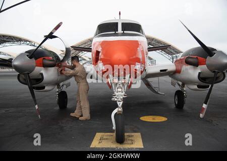 CORPUS CHRISTI, Texas (27. April 2021) LT. Pete Nguyen, ein Ausbilder-Pilot, der den „Wise Owls“ des Training Squadron (VT) 31 an Bord der Naval Air Station Corpus Christi zugewiesen wurde, führt eine Vorflugkontrolle auf einem T-44C Pegasus durch, 27. April 2021. VT-31 führt für die Marine, das Marine Corps, die Küstenwache und ausgewählte internationale Militärpartner intermediäre und fortgeschrittene mehrmotorige Flugtrainings durch. Stockfoto