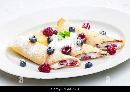 Pankaces gefüllt mit Heidelbeeren, Himbeeren und Rahm Stockfoto