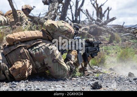 Infanteristen, die dem 2. Bataillon, dem 35. Infanterie-Regiment, dem Kampfteam der 3. Infanterie-Brigade und der 25. Infanterie-Division zugewiesen sind, führen am 27. April 2021 während einer Rotation zum Pohakuloa-Trainingsgebiet auf der Hawaii-Insel Live-Feuertrainingswege durch. Auf der ganzen Gasse verwendeten die Soldaten Unterdrücker auf ihren M4-Karbinen, um den Lärm ihres ersten Kontakts mit feindlichen Zielen zu schützen. Stockfoto