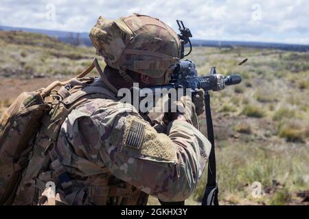 Infanteristen, die dem 2. Bataillon, dem 35. Infanterie-Regiment, dem Kampfteam der 3. Infanterie-Brigade und der 25. Infanterie-Division zugewiesen sind, führen am 27. April 2021 während einer Rotation zum Pohakuloa-Trainingsgebiet auf der Hawaii-Insel Live-Feuertrainingswege durch. Auf der ganzen Gasse verwendeten die Soldaten Unterdrücker auf ihren M4-Karbinen, um den Lärm ihres ersten Kontakts mit feindlichen Zielen zu schützen. Stockfoto