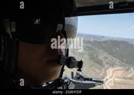 MARINE CORPS BASISLAGER PENDLETON, Kalifornien (27. April 2021) U.S. Marine Corps CPL. Scott Squires, ein UH-1Y Venom-Türschützer mit Marine Medium Tiltrotor Squadron (VMM) 165 (verstärkt), 11. Marine Expeditionary Unit (MEU), fliegt während einer Nahluftmission für eine amphibische Angriffsübung im April 27 über das Marine Corps Base Camp Pendleton, Kalifornien. Die Marineinfanteristen und Matrosen der 11. MEU und der Essex Amphibious Ready Group (ARG) führen vor der Küste Südkaliforniens Routinetraining durch. Zusammen werden das 11. MEU, das Amphibiengeschwader (PHIBRON) 1 und Schiffe als an bezeichnet Stockfoto