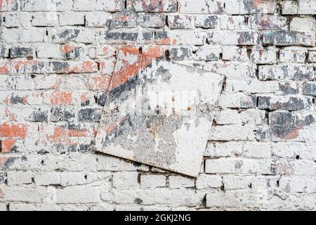 Alte, schmutzige Ziegelwand mit Metallplatte. Bunte Grunge Textur, abblätternder Putz. Abstrakter Vintage-Hintergrund, Kopierbereich Stockfoto