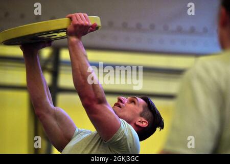 LUFTWAFFENSTÜTZPUNKT SCHRIEVER, Colorado -- Robert Hefner, Joint Task Force-Space Defense Future Operations Division, vervollständigt während der monatlichen Krieger-Trainingseinheit des U.S. Space Command eine über-Kopf-Presse mit einer 35-Pfund-Platte auf der Indoor-Laufstrecke der Schriever Air Force Base im April 28. Hefners Team absolvierte mehrere Läufe und Hunderte von Liegestützen, Rudern, Overhead-Pressen und Lufthocken mit der schnellsten Zeit. Stockfoto