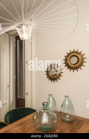 Schönes Vintage und modernes Dekor in einer Ferienwohnung mit einem Holztisch und Spiegeln Stockfoto