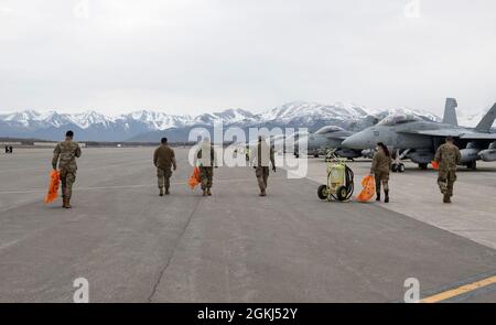 Die dem 3. Flügel zugewiesenen Flieger führen auf der Fluglinie auf der Joint Base Elmendorf-Richardson, Alaska, einen Fremdkörperablagerungen durch, der am 29. April 2021 durchgeführt wird. Die dem 3. Flügel zugewiesenen aktiven Militärflugzeuge, die Reserve-Flieger der 477. Kampfgruppe und die Alaska Air National Guardsmen des 176. Flügels führten den FOD-Spaziergang durch, um Trümmer zu entfernen, die möglicherweise Flugzeuge beschädigen und die Einsatzbereitschaft behindern könnten. Stockfoto