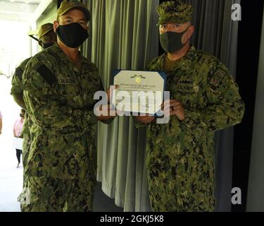 DIEGO GARCIA, Britisches Territorium im Indischen Ozean (29. April 2021) – Oberbefehlshaber Russel M. Wood, der Oberbefehlshaber der US Naval Support Facility, Diego Garcia, erhält von Kapitän R. Wade Blizzard, dem Kommandanten der NSF Diego Garcia, eine Medaille für die Auszeichnung der Marine und des Marine Corps. Während eines Quartals der Preisverleihung am 29. April 2021. NSF Diego Garcia bietet Logistik-, Service-, Freizeit- und administrative Unterstützung für US- und alliierte Truppen, die im Indischen Ozean und im Arabischen Golf eingesetzt werden. Stockfoto