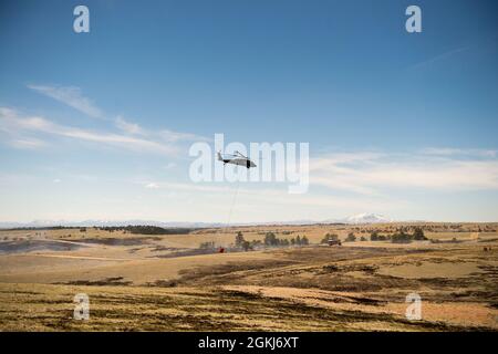 Ein UH-60 Blackhawk bereitet sich darauf vor, während eines vorgeschriebenen Verbrennungs- und Eimertropftrainings im North Training Area von Camp Guernsey am 29. April 2021 Wasser auf die Brandlinie zu Tropfen. Stockfoto