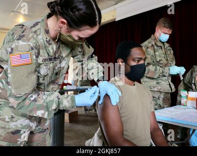 Spc. Star O’Donnell, ein Sanitäter, der der 108. Unterstützung der medizinischen Gesellschaft der Pennsylvania Guard zugewiesen wurde, verwaltet am 30. April 2021 die Johnson & Johnson (Janssen)-Impfung gegen COVID-19 an Soldaten am Standort Powidz, Polen. Seit die Food and Drug Administration and Centers for Disease Control Sicherheitskontrollen abgeschlossen und empfohlen haben, die Pause bei der Verwendung des Janssen-Impfstoffes zu unterbrechen, haben die Militärmedizinischen Behörden schnell Massenimpfungen verschoben, um entsandt Personal zu impfen, das den Impfstoff erhalten hat. Stockfoto