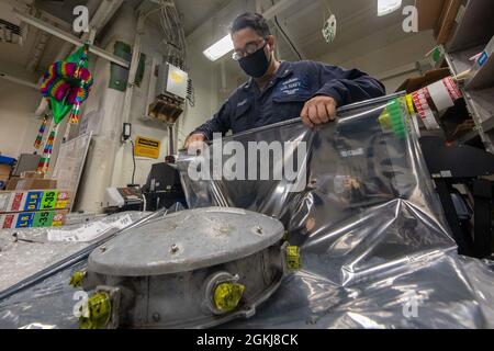 PAZIFIK (29. April 2021) – Jose Ramirez, Spezialist für Logistik der US-Marine der 3. Klasse, bereitet Teile für den Versand an Bord des amphibischen Angriffsschiffs USS Makin Island (LHD 8) vor. Die Makin Island Amphibious Ready Group und die 15. Marine Expeditionary Unit führen Routineoperationen im Einsatzgebiet der 3. US-Flotte durch. Stockfoto