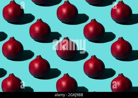 Granatapfelfrucht multipliziert auf trendigem aquamarinblauen Hintergrund. Minimales abstraktes Sommer- und Tropenfruchtkonzept. Stockfoto