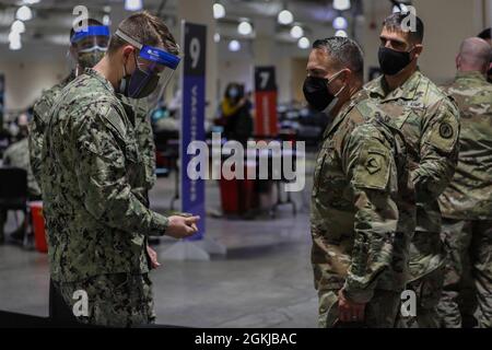 Der Hospitalist der US-Marine Dylan Crawford, links, dem Naval Medical Center Portsmouth, Virginia, zugewiesen, erhält eine Münze von der US-Armee Brig. General Ronald Cupples, rechts, der stellvertretende Generaladjutant der Nationalgarde von Massachusetts, weil er vom 19. Bis 25. April der Vaccinator der Woche war und etwa 840 lokale Gemeindemitglieder impfen konnte, im Community Impfzentrum im Hynes Convention Center in Boston, 30. April 2021. Das U.S. Northern Command setzt sich über die U.S. Army North weiterhin dafür ein, dem Federal Emergency Management weiterhin flexible Unterstützung durch das Verteidigungsministerium zu leisten Stockfoto