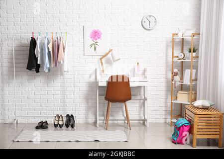 Regal mit stilvoller Schuluniform im Innenraum des Zimmers Stockfoto