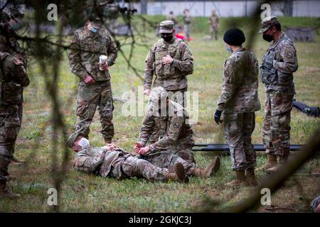 Ein Soldat der Alpha Company, 24. Militärgeheimdienstbataillon, 66. Militärgeheimdienstbrigade, bietet im Rahmen der Anglerfish Day-Evakuierungsschulung für Fahrer und Opfer im Dagger Complex, Deutschland, 30. April 2021, simulierte medizinische Behandlung an. Alle teilnehmenden Soldaten erhielten eine grundlegende Schulung in den Bereichen Fahrerwissen und vorbeugende Wartungskontrollen und -Dienste, Bekämpfung von Lebensretter und taktischer Bekämpfung der Unfallversorgung, Funketikette und medizinische Evakuierung in neun Leitungen, Kommunikationssicherheit und Reaktion auf Kontakt. Stockfoto