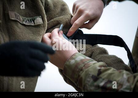 Ein Soldat, der der Alpha Company, dem 24. Militärgeheimdienstbataillon, der 66. Militärgeheimdienstbrigade, zugewiesen wurde, wendet im Rahmen der Anglerfish Day-Evakuierungsschulung für Fahrer und Opfer im Dagger Complex, Deutschland, am 30. April 2021, einen Absturzabwehreinsatz an. Alle teilnehmenden Soldaten erhielten eine grundlegende Schulung in den Bereichen Fahrerwissen und vorbeugende Wartungskontrollen und -Dienste, Bekämpfung von Lebensretter und taktischer Bekämpfung der Unfallversorgung, Funketikette und medizinische Evakuierung in neun Leitungen, Kommunikationssicherheit und Reaktion auf Kontakt. Stockfoto