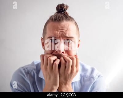 Weißer junger Mann sieht traurig, gestresst und deprimiert aus Stockfoto