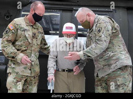 COL Gary Lewis, Kommandant der 63. TAB und Command Sgt. Maj. Paul Rezac, Senior Enlisted Advisor für die 63. REGISTERKARTE, stellt GB Jones, Veteran des Zweiten Weltkriegs, am 30. April 2021 in Frankfort Kentucky eine 63. Tab-Münze und einen Patch in der Army Aviation Support Facility der Kentucky National Guard vor. Drei alteingesessene Bewohner, ein alteingesessener Freiwilliger und drei medizinische Mitarbeiter einer langfristigen Gesundheitseinrichtung in Lexington machten eine Führung durch den Hangar und checkten das Flugzeug und die Ausrüstung aus. Stockfoto