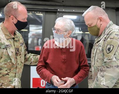 COL Gary Lewis, Kommandant der 63. TAB und Command Sgt. Maj. Paul Rezac, Senior enlisted Advisor für den 63. TAB Gegenwart WWII Veteran, Jim Gotham mit einer 63. Tab Münze und Patch in der Kentucky National Guard's Army Aviation Support Facility am 30. April 2021 in Frankfort Kentucky. Drei alteingesessene Bewohner, ein alteingesessener Freiwilliger und drei medizinische Mitarbeiter einer langfristigen Gesundheitseinrichtung in Lexington machten eine Führung durch den Hangar und checkten das Flugzeug und die Ausrüstung aus. Stockfoto