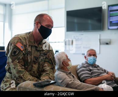 COL Gary Lewis, Kommandant der 63. TAB, lacht, als er am 30. April 2021 in Frankfort Kentucky Geschichten von Veteranen des Zweiten Weltkriegs in der Army Aviation Support Facility der Kentucky National Guard hörte. Drei alteingesessene Bewohner, ein alteingesessener Freiwilliger und drei medizinische Mitarbeiter einer langfristigen Gesundheitseinrichtung in Lexington machten eine Führung durch den Hangar und checkten das Flugzeug und die Ausrüstung aus. Stockfoto