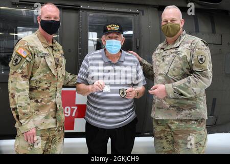 COL Gary Lewis, Kommandant der 63. TAB und Command Sgt. Maj. Paul Rezac, Senior enlisted Advisor für den 63. TAB Gegenwart WWII Veteran, Jerry Fall mit einem 63. Tab Münze und Patch in der Kentucky National Guard's Army Aviation Support Facility am 30. April 2021 in Frankfort Kentucky. Drei alteingesessene Bewohner, ein alteingesessener Freiwilliger und drei medizinische Mitarbeiter einer langfristigen Gesundheitseinrichtung in Lexington machten eine Führung durch den Hangar und checkten das Flugzeug und die Ausrüstung aus. Stockfoto