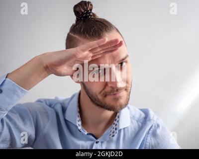 Glücklicher weißer junger Mann gibt einen ungeschickten militärischen Gruß Stockfoto