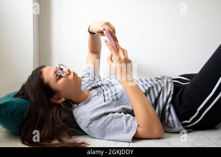 Frau auf dem Boden mit Handy. Stockfoto