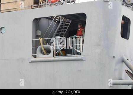 Ein US-Armeesoldat der 109th Transportation Co., 259th Transportation Bn., beobachtet eine Landung im Hafen von Durres vom Deck des Logistikunterstützungsschiffs der US-Armee, MG Charles P. Gross, 1. Mai 2021, in Durres, Albanien. Während der NUN laufenden gemeinsamen Überlandoperationen VON DEFENDER-Europe 21 in der Logistik arbeiten Armee und Marine mit multinationalen Verbündeten und Partnern zusammen, um die Fähigkeit zu demonstrieren, Truppen, Lieferungen und Ausrüstung in aller Welt als Reaktion auf die Krise schnell zu liefern. DEFENDER-Europe ist eine jährlich stattfindende, von der US-Armee geführte, multinationale, gemeinsame Übung Stockfoto