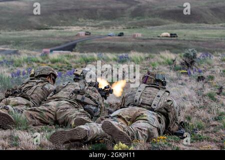 Soldaten der US-Armee, die dem 1. Bataillon, dem 17. Infanterie-Regiment, dem 2. Stryker Brigade Combat Team, der 7. Infanterie-Division zugewiesen sind, decken das Feuer ab, während sie eine Leerfeuerbewegung durchführen, um während des Bajonett-Fokus im Yakima Training Center am 3. Mai 2021 mit Übungen in Kontakt zu treten. Bajonett Focus ist eine mehrtägige Zertifizierungsübung für die untergeordneten Brigaden der 7. Infanteriedivisionen, die einzelne und kollektive Soldatenaufgaben prüft, bevor die Brigade ihre Rotation im National Training Center durchführt. Stockfoto