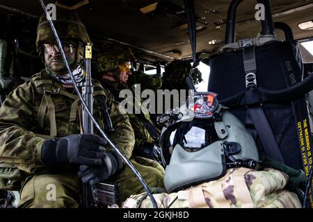 Soldaten der estnischen Verteidigungsliga führen an Bord eines Helikopters der UH-60 Blackhawk Kaltlastübungen durch, um sich auf die Swift Response 21, eine verbundene Übung von DEFENDER-Europe 21, in der Nurmsi Drop Zone, Estland, 4. Mai 2021 vorzubereiten. Die Ausbildung wurde von einer Flugbesatzung der Bravo Company, des 3. Bataillons, der 1. Kampfluftfahrtbrigade, der 1. Infanteriedivision durchgeführt. DEFENDER-Europe ist eine jährliche, von der US-Armee geführte, multinationale, gemeinsame Übung, die darauf ausgerichtet ist, Bereitschaft und Interoperabilität zwischen den USA, der NATO und den Partnermilitärs aufzubauen. In diesem Jahr werden mehr als 28,000 multinationale Streitkräfte aus 27 Nationen zusammenarbeiten Stockfoto