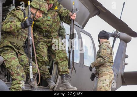 NURMSI, Estland – Oberbefehlshaber der US-Armee 2 Lindsay Walker, ein UH-60-Blackhawk-Pilot der Bravo Company, 3. Bataillon, 1. Kampfluftfahrtbrigade, 1. Infanteriedivision, überblickt die Soldaten der Estnischen Verteidigungsliga, als sie aus einem Blackhawk-Hubschrauber steigen und Kaltladungsoperationen durchführen, hier, 4. Mai 2021. Mit dieser Schulung werden die Bereitschaft und Interoperabilität mit den estnischen Streitkräften wachsen und Abschreckung gegen jede gegnerische Bedrohung in einer Zeit des Konflikts zeigen, wenn sie kommt. Stockfoto