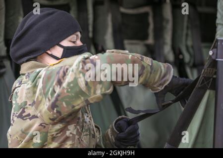 NURMSI, Estland – Oberbefehlshaber der US-Armee 2 Lindsay Walker, ein UH-60-Blackhawk-Pilot der Bravo Company, des 3. Bataillons, der 1. Kampfluftfahrtbrigade, der 1. Infanteriedivision, bereitet die Sicherheitsgurte eines Blackhawk-Hubschraubers auf, damit die Soldaten der Estnischen Verteidigungsliga ordnungsgemäß Kaltladungsoperationen durchführen können, hier, 4. Mai 2021. Mit dieser Schulung werden die Bereitschaft und Interoperabilität mit den estnischen Streitkräften wachsen und Abschreckung gegen jede gegnerische Bedrohung in einer Zeit des Konflikts zeigen, wenn sie kommt. Stockfoto