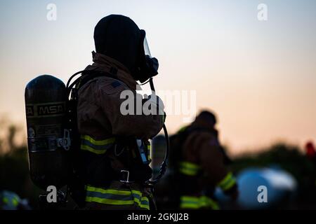 Feuerwehrleute, die dem 7. Civil Engineer Squadron und der 512. CES zugewiesen wurden, feuern die Dämmerung an, bevor sie nächtliche Feuertrainings auf der Dyess Air Force Base, Texas, am 4. Mai 2021, durchführen. Die 7. CES-Feuerwehrleute führen routinemäßig Schulungen durch, um die Sicherheit und das Fachwissen bei der Brandbekämpfung zu verbessern. Stockfoto